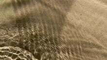 Close-up Water Surface Ripples And Splash, Palm Tree Leaf Shadow On Sand Texture