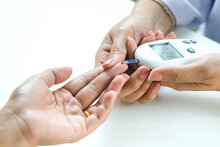 Hand Of People Check Diabetes And High Blood Glucose Monitor With Digital Pressure Gauge. Healthcare And Medical Concept	
