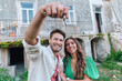 © Westend61 - Happy couple with keys standing together in front of house