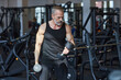 © Westend61 - Strong mature man doing exercise with dumbbells in gym