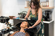 © Westend61 - Hairdresser washing woman's hair at salon