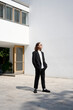 © Westend61 - Young man wearing suit standing in front of building
