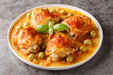 Wall Mural - Mediterranean chicken thigh baked with green olives and onion paprika sauce close-up in a plate on the table. Horizontal
