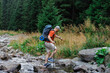 © Vadim - Male hiker crossing creek in forest