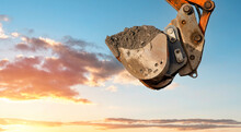 Excavator Rising Bucket Against Sky Background