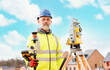 © Iryna - Surveyor builder site engineer with theodolite total station at construction site outdoors during surveying work