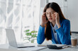 © PHOTO4U - Asian woman in a startup company office, businesswoman poses stressed and body aches due to long hours of hard work, office syndrome among working people. Office syndrome concept and hard work.