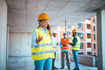 Shot of a young engineer using a smartphone in an industrial place of work. Architect is using mobile phone on construction site. 