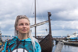 Fototapeta  - woman tourist went ashore after sailing in a modern replica of anсient viking longship
