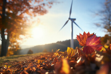 Renewable energy concept with autumn leaves in foreground and wind mill turbine in blurry background