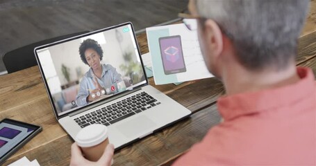 Wall Mural - Caucasian businessman on laptop video call with african american female colleague on screen