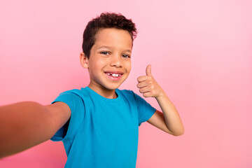 Canvas Print - Photo of cool confident small boy wear blue t-shirt recording video vlog showing thumb up isolated pink color background