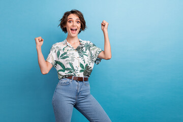 Sticker - Photo portrait of lovely young lady raise fists celebrate promotion dressed stylish print leaves garment isolated on blue color background