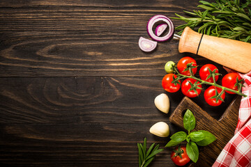 Wall Mural - Ingredients for cooking. Food background with spices, herbs and vegetables at wooden kitchen table. Top view with copy space.