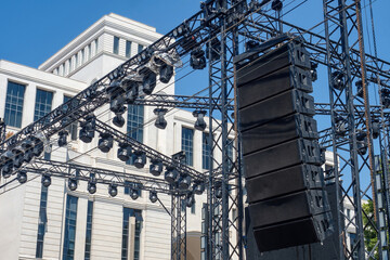 Wall Mural - Concert equipment. Music column hangs on metal support. Spotlights above stage. Concert equipment above place where artists perform. Technique for music festival. Concert technologies