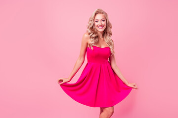 Photo of cute cheerful lovely girl toothy smile have good mood arms hold dress dancing isolated on pink color background