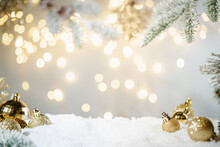 Christmas Holiday Background With Snow, Fir Tree And Decorations With Christmas Light Behind