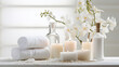 Beautiful spa salon white composition in wellness center. Spa still life with aromatic candles, orchid flower, massage oil and towel. Beauty spa treatment and relax. Relaxing white background.