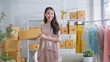 © Yingyaipumi - SME owner and Startup small business entrepreneur.Young Asian women using a laptop and packing with box Cheerful success.SME owner Asia people young woman record video,live streaming online at shop.