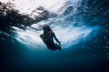 Wall Mural - Woman underwater with ocean wave and sun light. Vacations in ocean
