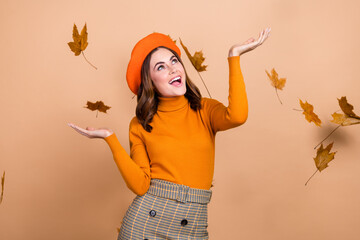 Poster - Photo of joyful glad adorable lady catching dry dropping leaves have fun good mood enjoy nice weather isolated on beige color background