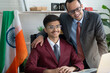 © chomplearn_2001 - Indian businessman father and son smiling at desk, businessman father is proud to have his son help him at the company