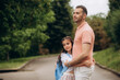 © Roman - loving family. a caring dad accompanies a little girl with backpacks to school. The child smiles and looks over his shoulder. Close-up. Back to school. the first day of training