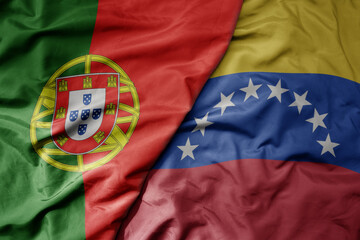 big waving national colorful flag of portugal and national flag of venezuela .