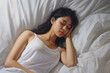 © dinastya - Young woman in white shirt sleeping on a white pillow, relaxed and comfortable concept, top view.