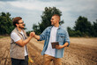 © cherryandbees - Two Caucasian men greeting one another inn the field before work.
