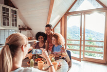 Young And Diverse Group Of Female Friends Taking A Picture On A Smartphone And Having Breakfast While On A Holiday Vacation In A Cabin House