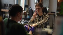 Portrait Of Young Man Talking On Phone As Woman Doing Manicure For Client In Slow Motion. Medium Shot Caucasian Satisfied Client With Professional Beautician Manicurist In Beauty Salon Indoors
