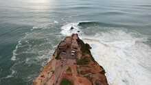 Top-down Aerial View Of The People On The Fort Of Sao Miguel Arcanjo Lighthouse In Nazare, Portugal. Nazare Is Famously Known For Having The Biggest Waves In The World.