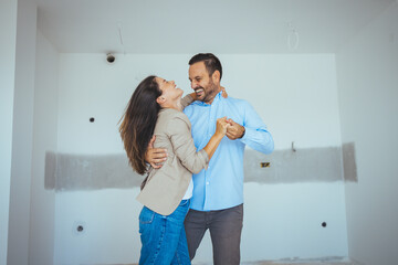 Wall Mural - Dancing Couple Happy With Apartment Choice. Relocation, real estate, rent concept. Happy and Excited Young Couple Look Around In Wonder at their Newly Purchased