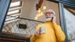 © Miljan Živković - One senior man stand in at door of tiny house in day use smart phone
