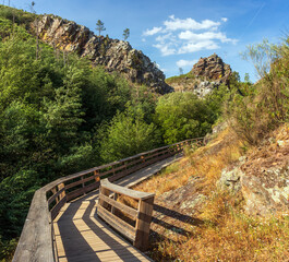 Wall Mural - Beautiful landscape of the Penedo Furado walkways in Vila de Rei, Portugal, with the walkways surrounded by trees and large rock formations in the background.