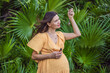 © galitskaya - pregnant woman after 40 demonstrating the use of an aroma pendant, combining style and aromatherapy during her pregnancy journey