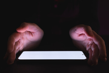 Poster - Tablet with copy space and glowing light screen and caucasian hands on black background