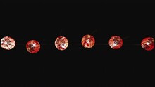 Red Chinese Paper Lanterns Hanging On Wire In Darkness, Blown By Wind.