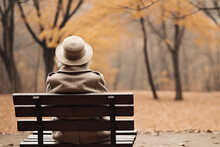 Elderly Woman Sitting On A Bench In Nature, Back View