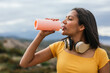 © ADDICTIVE STOCK CORE - Ethnic woman drinking water from reusable bottle