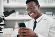© Talia Mdlungu/peopleimages.com - Man, medical science and a phone in a laboratory for online communication, email or website. Happy African scientist person with smartphone typing medicine research, social media or network database