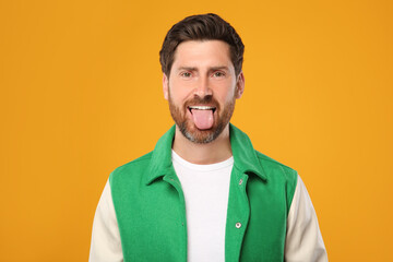 Poster - Man showing his tongue on orange background