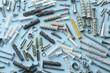 Many different fasteners and dowels on light blue background, flat lay