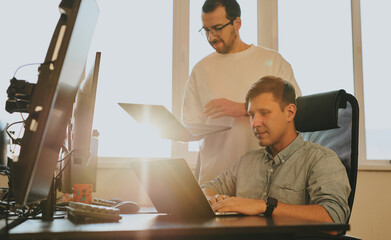 Portrait of two professional male programmers working on computer in diverse offices. Modern IT technologies, development of artificial intelligence, programs, applications and video games concept