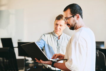 portrait of two professional male programmers working on computer in diverse offices. modern it tech