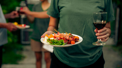 Home Garden BBQ Party, Wine Glasses Clink in Family Toast, enjoying harvest time together outside at front of house, grandfather and grandfather asian people, man and woman