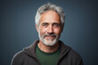 © Cherstva - Portrait of adult man with grey hair smiling and looking front view on blue background. Diverse age concept