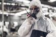 © kanpisut - Scientist wear Chemical protection suit check danger chemical, working at dangerous zone in Red and White Lines of barrier tape. Red and white Hazardous restricted area factory safety worker industry