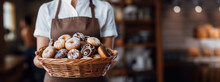 A Female Pastry Chef Holds A Basket Of Fresh Delicious Donuts. Banner, Place For Text